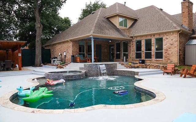 view of swimming pool with a patio area and a pool with connected hot tub