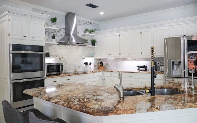 kitchen with wall chimney exhaust hood, appliances with stainless steel finishes, open shelves, and decorative backsplash