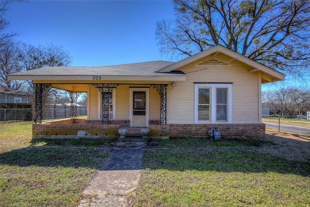 view of front of property featuring fence, a front lawn, a porch, and brick siding