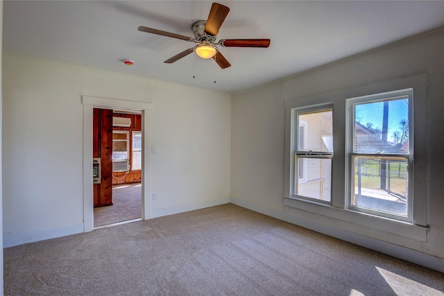 spare room with baseboards, ceiling fan, carpet, and a wall mounted air conditioner