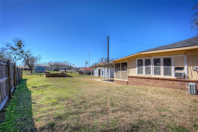 view of yard featuring a fenced backyard, cooling unit, and a carport