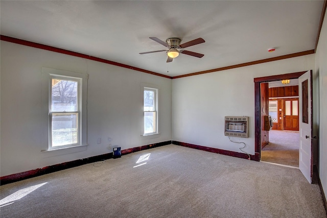 unfurnished room featuring baseboards, carpet flooring, crown molding, and heating unit