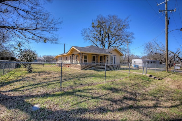 exterior space featuring a front lawn, a fenced front yard, and a shingled roof