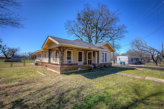 view of property exterior with covered porch, a gate, fence, and a yard