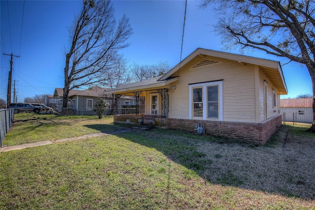 view of front of property featuring brick siding, a front yard, and fence