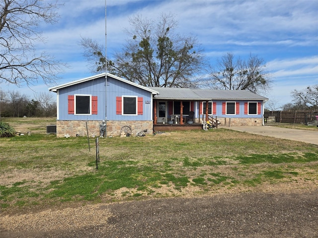 view of front of house featuring a porch, a front yard, and metal roof