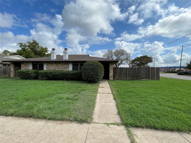 ranch-style house with a chimney, fence, a front lawn, and brick siding