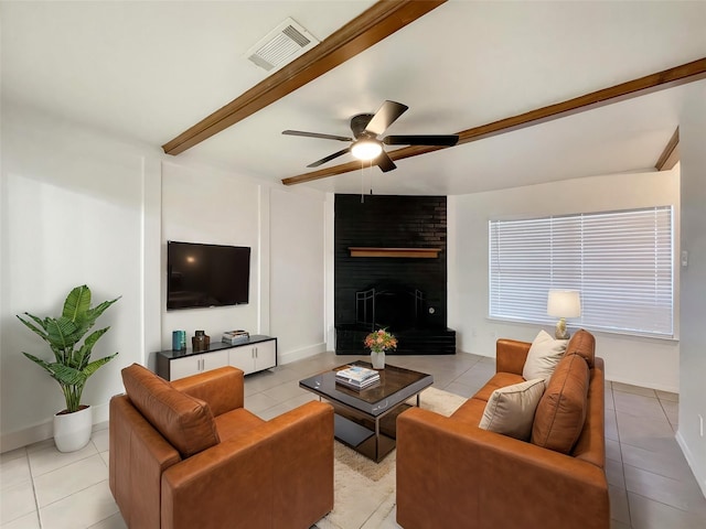 living room with visible vents, a fireplace, beamed ceiling, and light tile patterned floors