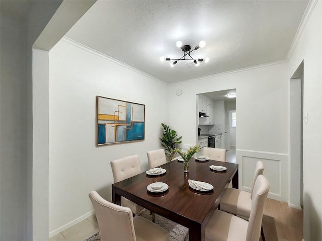 dining area with a notable chandelier, baseboards, and crown molding