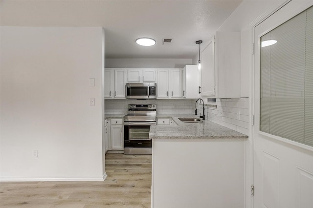 kitchen featuring stainless steel appliances, a sink, visible vents, white cabinets, and light wood finished floors