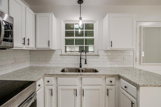 kitchen featuring range with electric stovetop, a sink, white cabinetry, tasteful backsplash, and stainless steel microwave