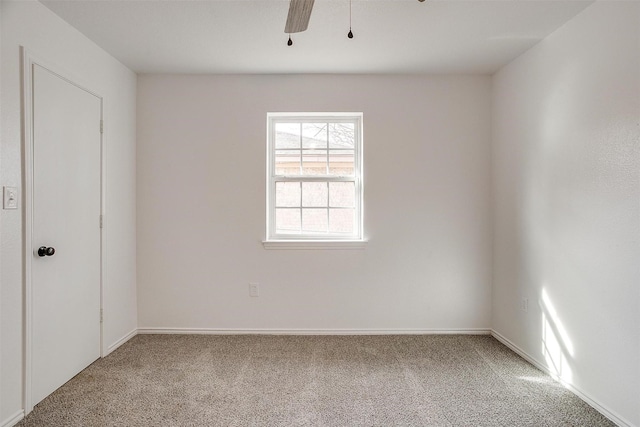 carpeted empty room featuring ceiling fan and baseboards