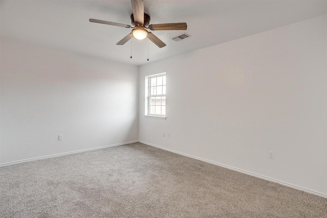 empty room featuring carpet, visible vents, ceiling fan, and baseboards