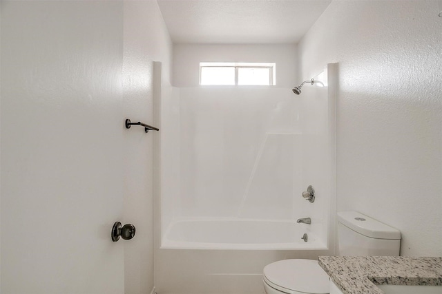 bathroom with toilet, a textured wall, vanity, and shower / bathtub combination