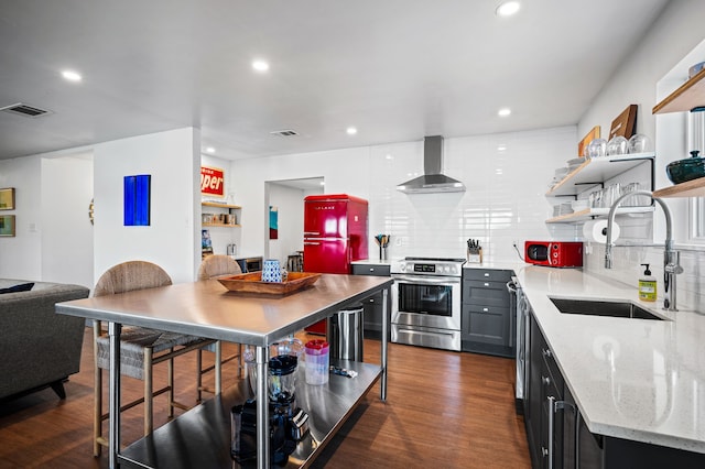 kitchen featuring dark wood-style flooring, electric stove, open shelves, a sink, and wall chimney exhaust hood