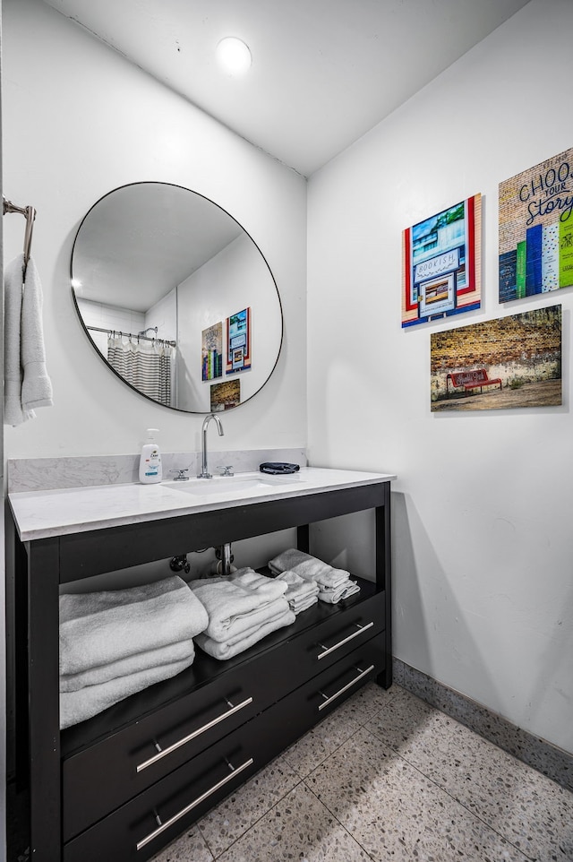 full bath with vanity and baseboards