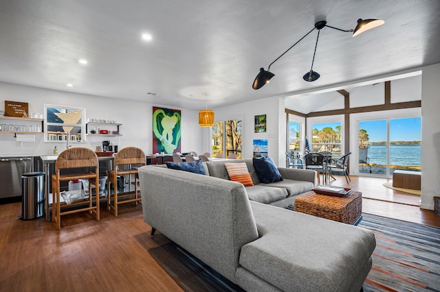 living area featuring a water view, plenty of natural light, dark wood finished floors, and recessed lighting