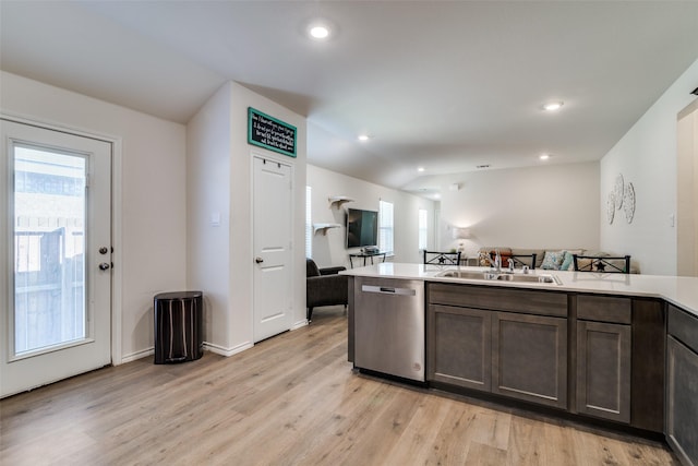 kitchen featuring light countertops, light wood-style floors, open floor plan, a sink, and dishwasher