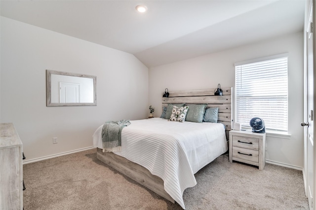 bedroom featuring light carpet, baseboards, and vaulted ceiling