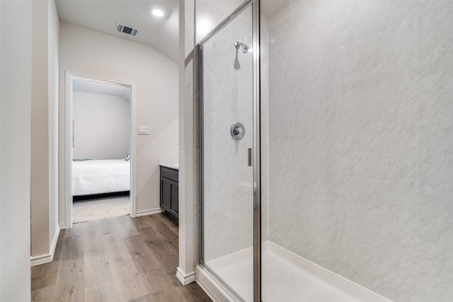 ensuite bathroom featuring visible vents, a stall shower, connected bathroom, vanity, and wood finished floors