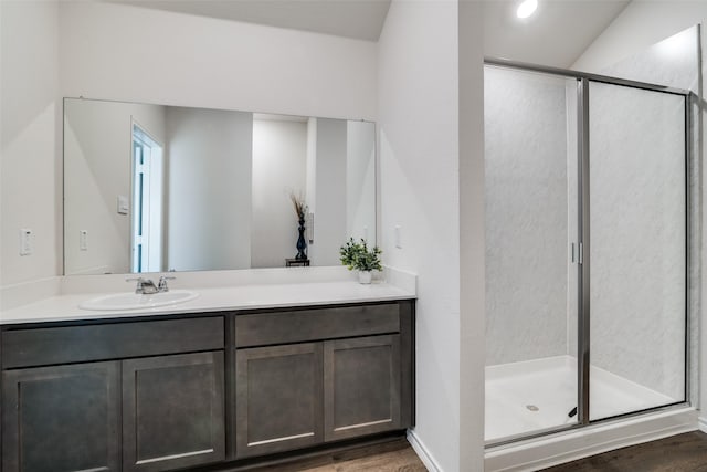 bathroom with a stall shower, vanity, and wood finished floors