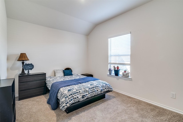 carpeted bedroom with lofted ceiling and baseboards