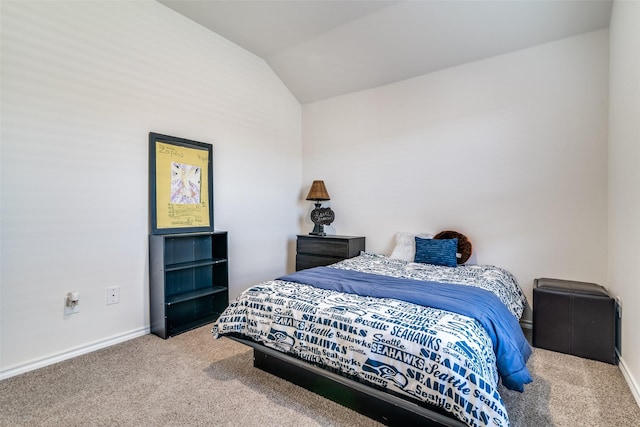 carpeted bedroom with lofted ceiling and baseboards