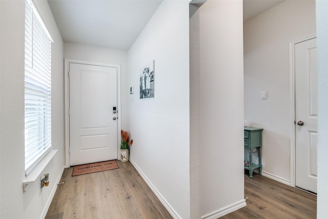 doorway to outside featuring wood finished floors and baseboards