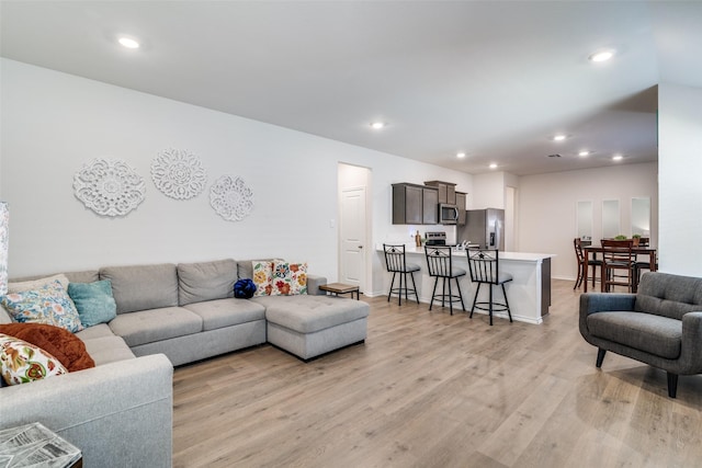 living room featuring light wood-style floors, recessed lighting, and baseboards