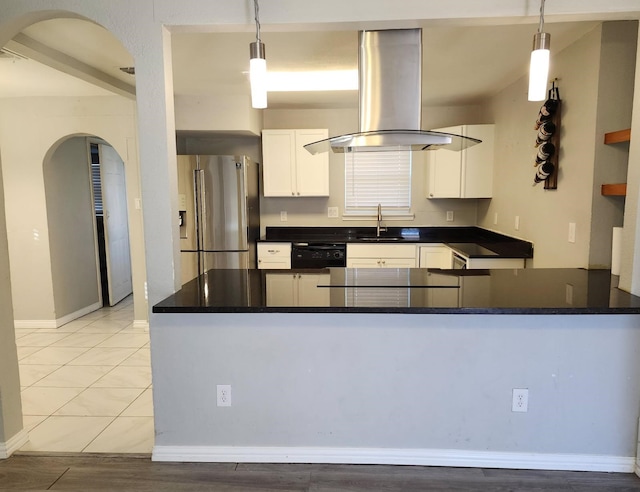 kitchen featuring dark countertops, island exhaust hood, a sink, and stainless steel fridge with ice dispenser