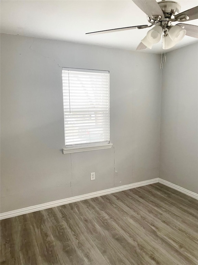 spare room featuring a ceiling fan, baseboards, and wood finished floors