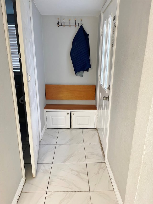 mudroom featuring marble finish floor and baseboards