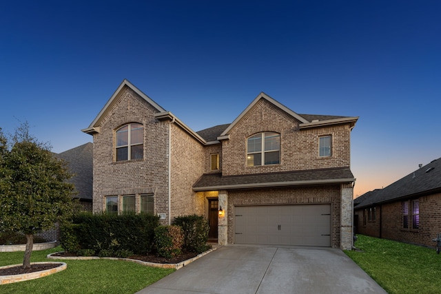 traditional-style home with a garage, concrete driveway, brick siding, and a front yard