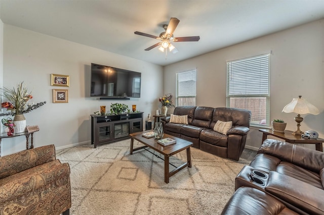 living room featuring light carpet, baseboards, and a ceiling fan