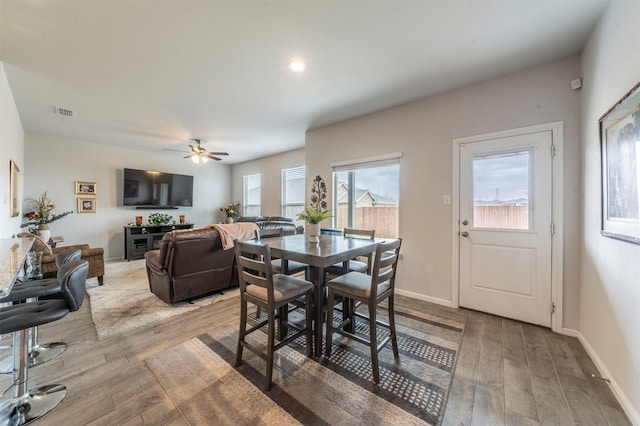 dining room featuring visible vents, ceiling fan, baseboards, and wood finished floors