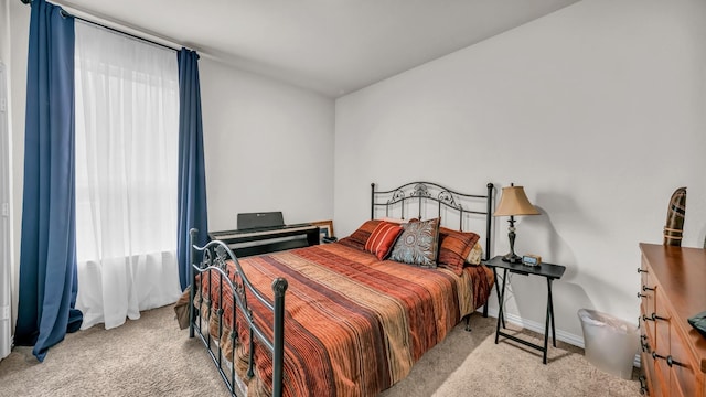 bedroom featuring light colored carpet and baseboards