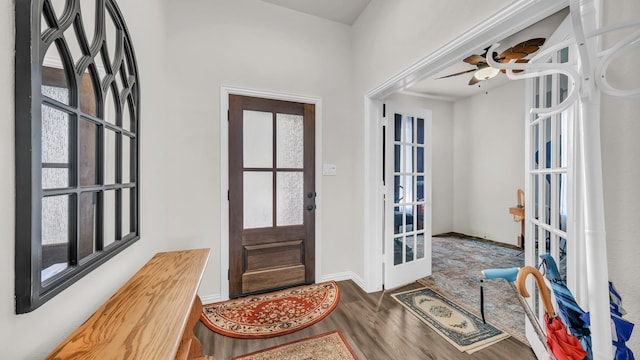 foyer with a ceiling fan, french doors, baseboards, and wood finished floors