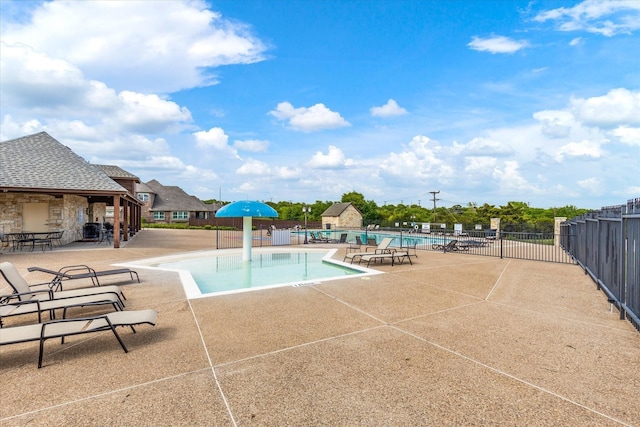 pool with a patio and fence