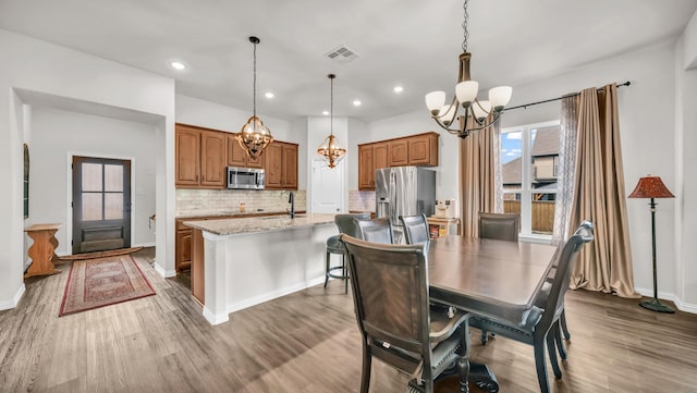 dining room featuring an inviting chandelier, visible vents, wood finished floors, and recessed lighting