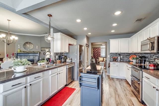 kitchen featuring visible vents, appliances with stainless steel finishes, light wood-style floors, white cabinets, and a sink