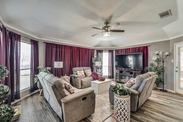 living room with a wealth of natural light, visible vents, and wood finished floors