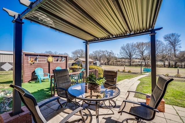 view of patio / terrace with a storage shed, an outbuilding, and outdoor dining space