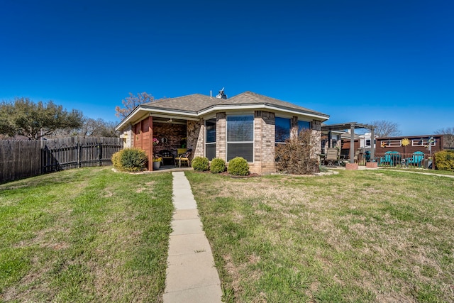 rear view of property with a yard, brick siding, fence, and a pergola