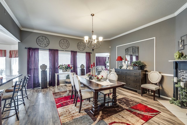 dining space featuring crown molding, wood finished floors, and a notable chandelier