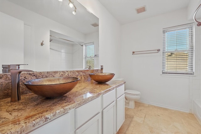 full bath with double vanity, visible vents, toilet, and a sink