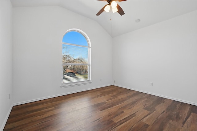 empty room featuring lofted ceiling, wood finished floors, a ceiling fan, and baseboards