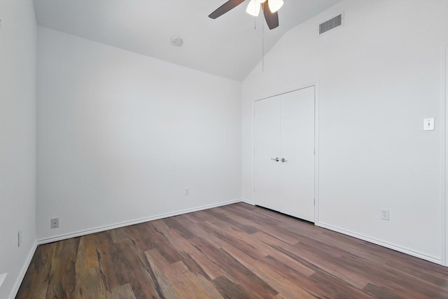 unfurnished room with lofted ceiling, ceiling fan, wood finished floors, visible vents, and baseboards