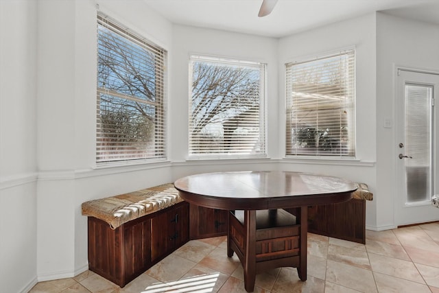 dining area featuring ceiling fan, breakfast area, light tile patterned flooring, and baseboards