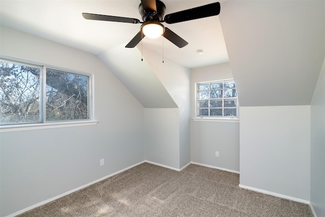 bonus room with lofted ceiling, carpet flooring, a ceiling fan, and baseboards