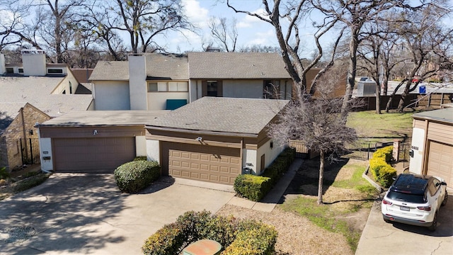 townhome / multi-family property featuring concrete driveway, an attached garage, fence, and stucco siding